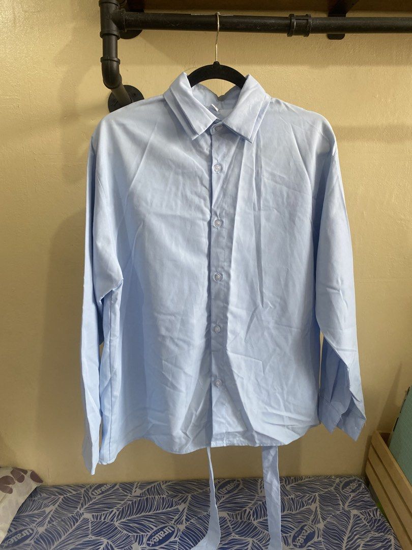 Light Blue Long Sleeve Button Up Shirt with Tie Back (Category: Longsleeves) located in Makati City. Submitted by slickthingsph (Listing ID 1452025676, Image 1). Description: - Light blue long sleeve shirt - Button-up front - Tie detail at the back - Relaxed fit - Versatile for casual wear or layering - Easy to style.