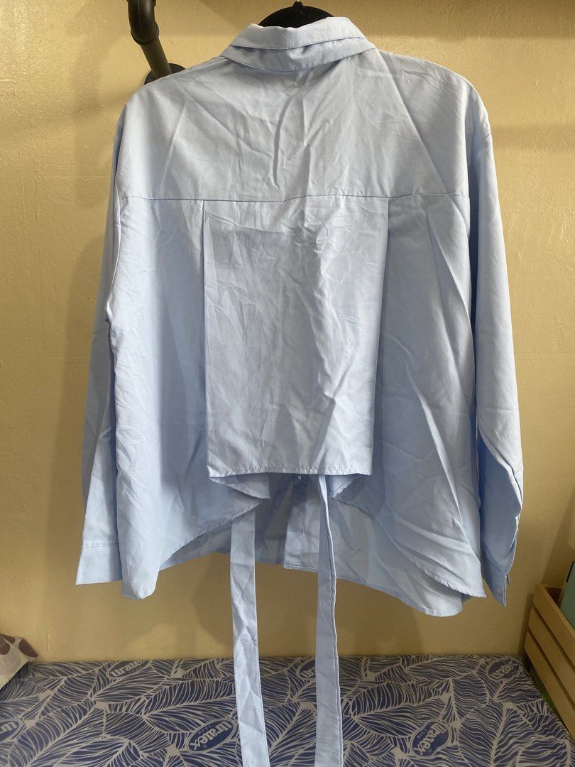 Light Blue Long Sleeve Button Up Shirt with Tie Back (Category: Longsleeves) located in Makati City. Submitted by slickthingsph (Listing ID 1452025676, Image 2). Description: - Light blue long sleeve shirt - Button-up front - Tie detail at the back - Relaxed fit - Versatile for casual wear or layering - Easy to style.