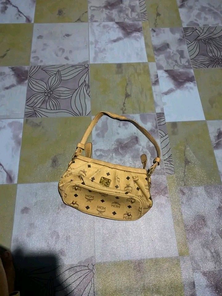 MCM Monogram Shoulder Bag (Category: Luxury Bags & Wallets) located in Manila. Submitted by bright.mayess (Listing ID 1452027983, Image 1). Description: - Classic MCM shoulder bag - Beige with all-over monogram print - Gold-tone hardware - Zipper closure - Interior zip pocket and small tag - Adjustable strap - Minor signs of wear on leather trim and strap - Ideal everyday bag.