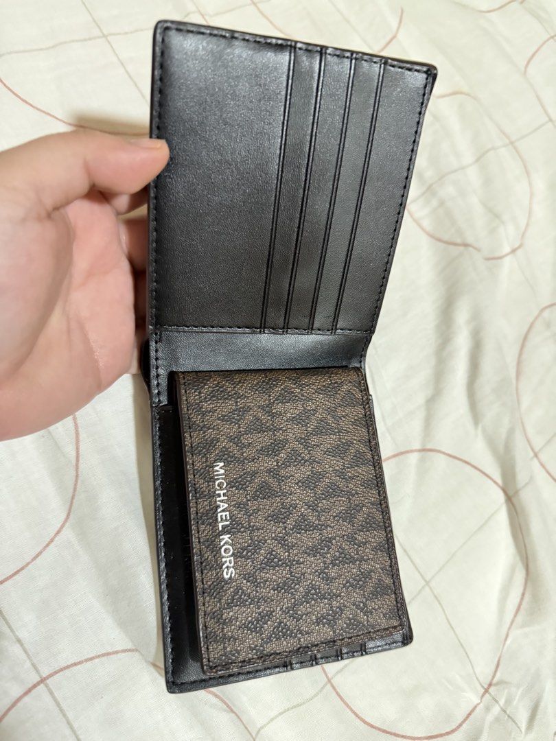 Michael Kors Monogram Bifold Wallet (Category: Luxury Bags & Wallets) located in Bambang. Submitted by valnyr24 (Listing ID 1452006440, Image 2). Description: - Authentic Michael Kors bifold wallet - Classic MK monogram print - Multiple card slots - Clear ID window - Black leather interior - Small embossed logo inside - Ideal for everyday use.