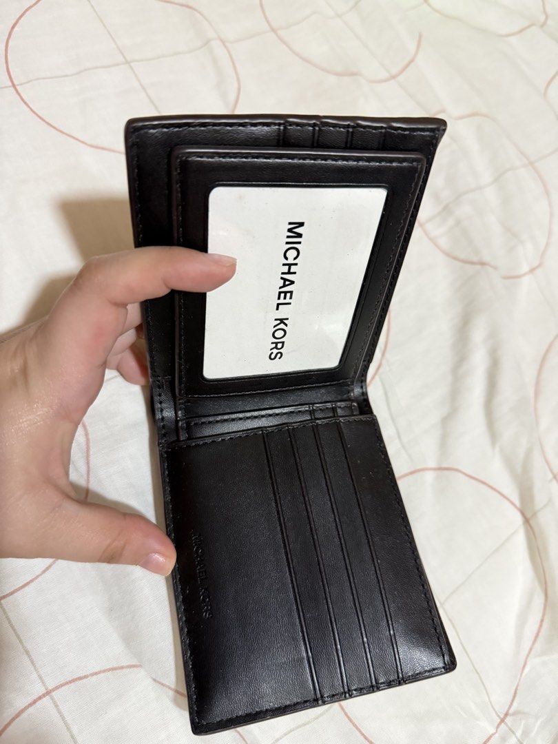 Michael Kors Monogram Bifold Wallet (Category: Luxury Bags & Wallets) located in Bambang. Submitted by valnyr24 (Listing ID 1452006440, Image 3). Description: - Authentic Michael Kors bifold wallet - Classic MK monogram print - Multiple card slots - Clear ID window - Black leather interior - Small embossed logo inside - Ideal for everyday use.
