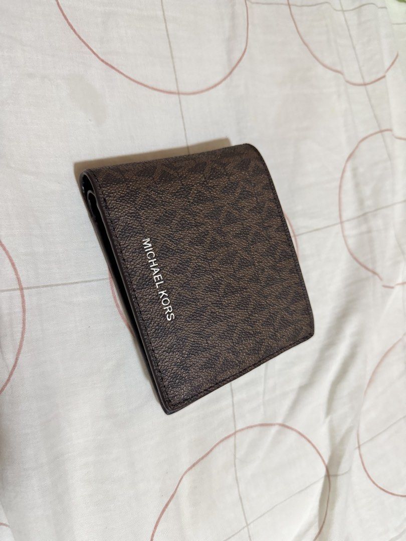 Michael Kors Monogram Bifold Wallet (Category: Luxury Bags & Wallets) located in Bambang. Submitted by valnyr24 (Listing ID 1452006440, Image 1). Description: - Authentic Michael Kors bifold wallet - Classic MK monogram print - Multiple card slots - Clear ID window - Black leather interior - Small embossed logo inside - Ideal for everyday use.