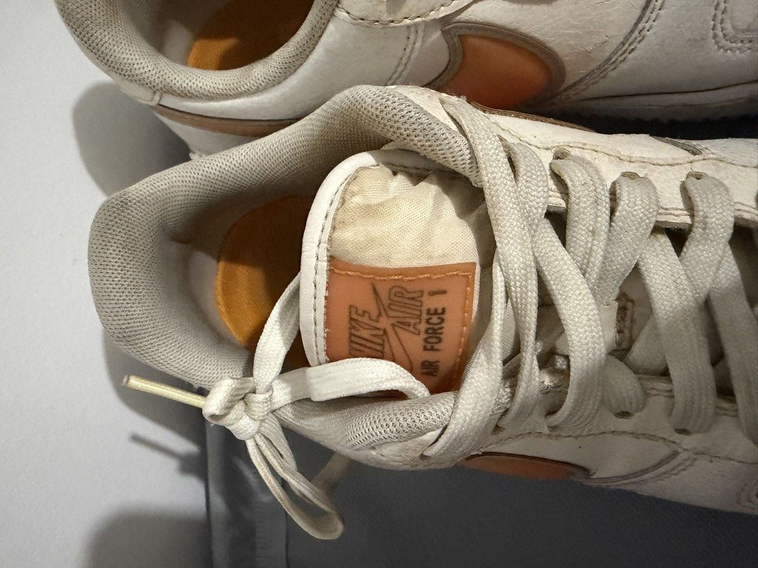 Nike Air Force 1 White Orange Sneakers (Category: Sneakers) located in Santa Rosa. Submitted by mm024 (Listing ID 1451946816, Image 3). Description: - White and orange Nike Air Force 1s - Visible wear and tear on leather, particularly toe boxes - Soles are dirty - Shoes have been worn but still have plenty of life left.