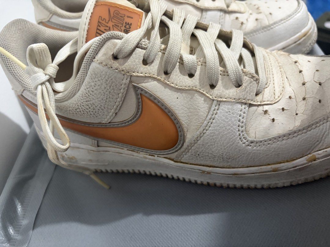 Nike Air Force 1 White Orange Sneakers (Category: Sneakers) located in Santa Rosa. Submitted by mm024 (Listing ID 1451946816, Image 2). Description: - White and orange Nike Air Force 1s - Visible wear and tear on leather, particularly toe boxes - Soles are dirty - Shoes have been worn but still have plenty of life left.