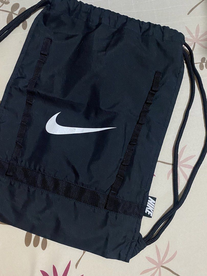 Nike Black Drawstring Bag (Category: Backpacks) located in Manila. Submitted by mpt99876 (Listing ID 1452067625, Image 2). Description: - Classic black Nike drawstring bag - Features the iconic Nike swoosh logo - Adjustable shoulder straps double as drawstring closure - Small Nike tag detail on the side - Perfect for gym sessions or everyday errands - Ample space for your essentials.