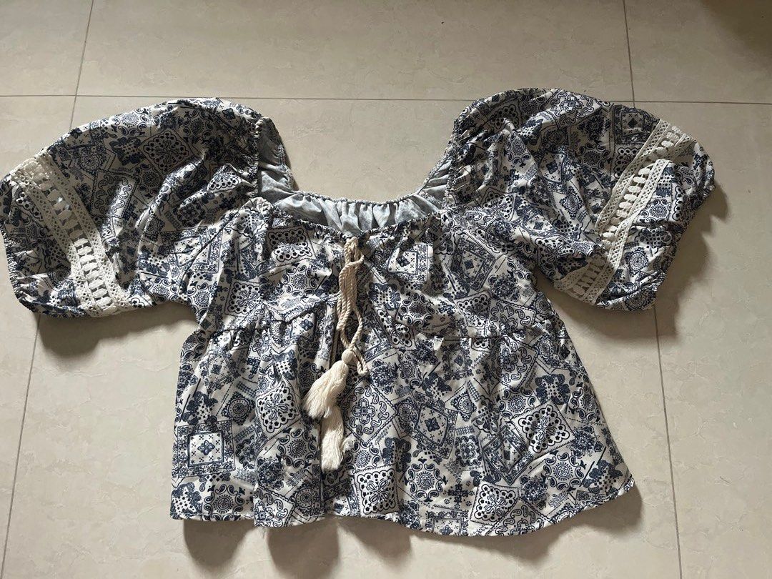 Patterned Top (Category: Other Tops) located in Singapore. Submitted by sy.clothesz (Listing ID 1451917841, Image 1). Description: - Trendy patterned top with blue and white bandana-style print. - Features puff sleeves with delicate lace trim. - Causal wear.