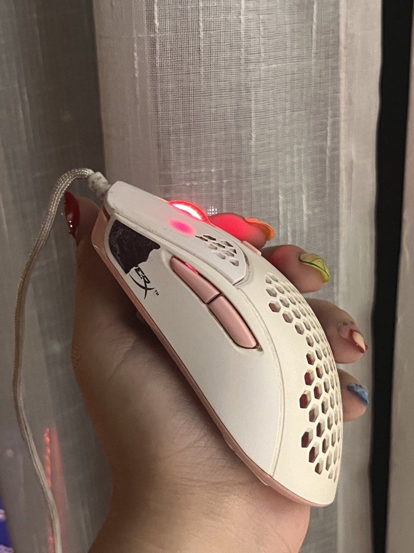 (Pink & White) HyperX Pulsefire Haste Gaming Mouse White Pink (Category: Mouse & Mousepads) located in Makati City. Submitted by belladonna.ph_ (Listing ID 1452053736, Image 1). Description: White & pink 🩷🎀 HyperX Pulsefire Haste gaming mouse! Lightweight honeycomb design, RGB scroll wheel. Minor signs of wear, works perfectly. The black thing on it is grip pad provided by HyperX, comes with the mouse. Will be removed and cleaned upon request. 