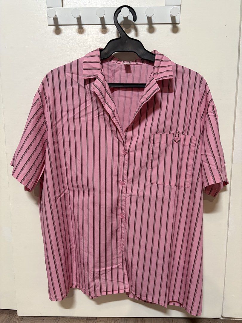 Pink Striped Button-Up Shirt Size M (Category: Shirts) located in Taguig. Submitted by cftbncs (Listing ID 1452040405, Image 1). Description: - Pink short-sleeved shirt - Features dark vertical stripes - Single chest pocket with button closure - Full button-up front - Tagged size M - Ideal for casual wear.
