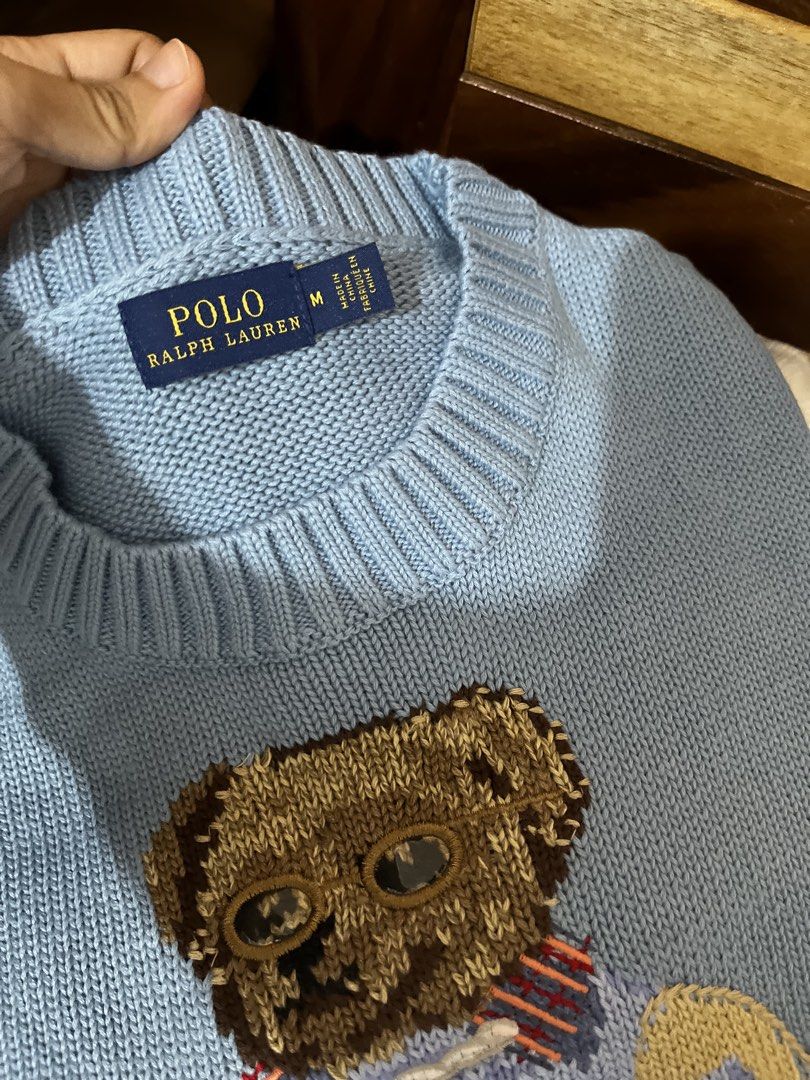 Polo Ralph Lauren Bear Sweater (Category: Coats, Jackets and Outerwear) located in Quezon City. Submitted by classychicph92 (Listing ID 1451724288, Image 3). Description: - Light blue sweater with iconic Polo Bear graphic - Polo Bear is wearing sunglasses and a sweater, holding a basket - Estimated size: Medium - Ideal for a casual, preppy aesthetic - Versatile for pairing with jeans or skirts.