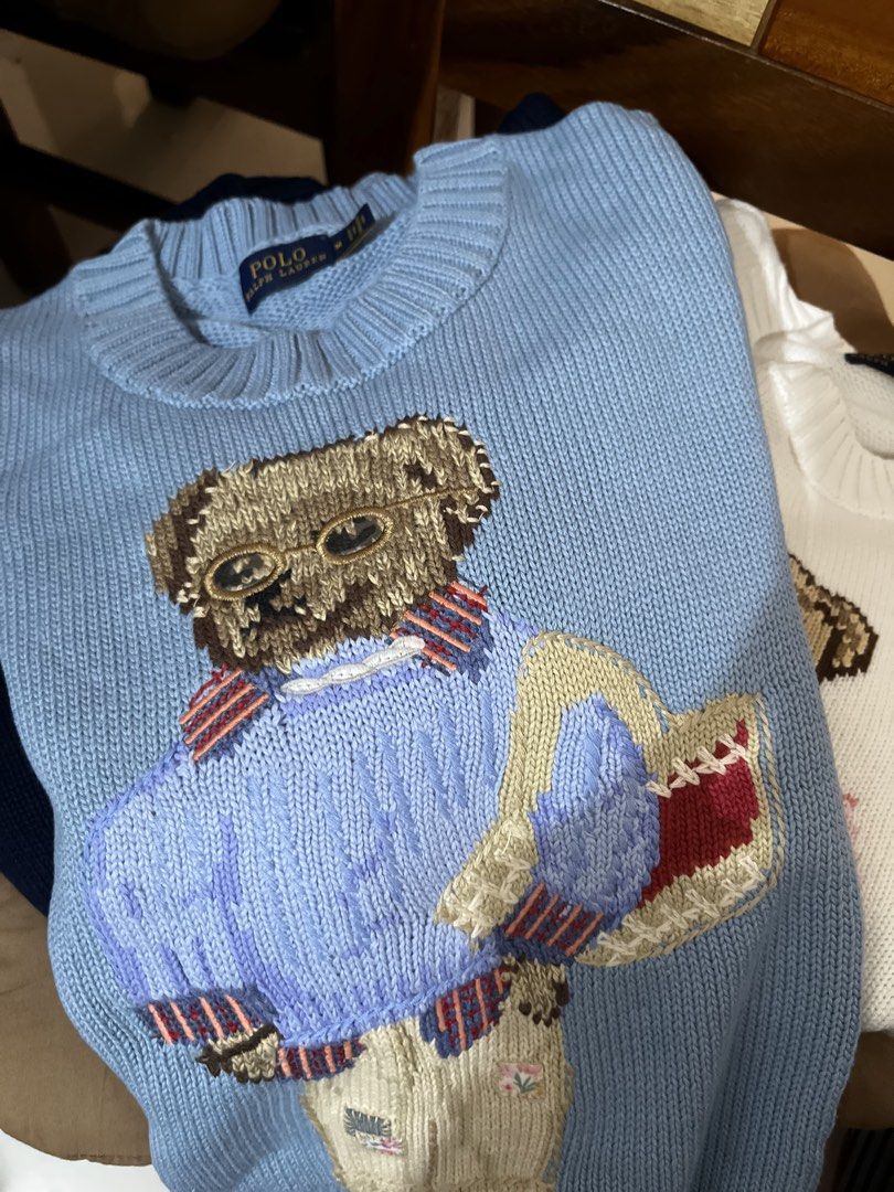 Polo Ralph Lauren Bear Sweater (Category: Coats, Jackets and Outerwear) located in Quezon City. Submitted by classychicph92 (Listing ID 1451724288, Image 2). Description: - Light blue sweater with iconic Polo Bear graphic - Polo Bear is wearing sunglasses and a sweater, holding a basket - Estimated size: Medium - Ideal for a casual, preppy aesthetic - Versatile for pairing with jeans or skirts.