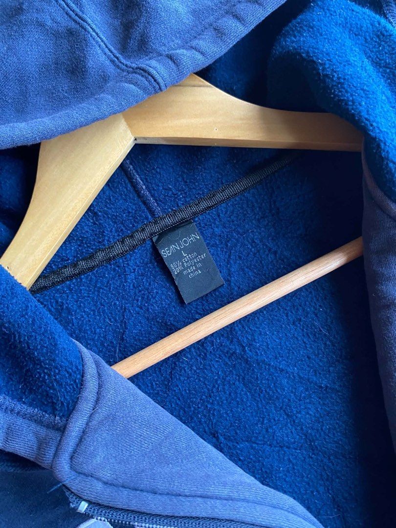 Sean John Navy Blue Zip-Up Hoodie (Category: Hoodies) located in Davao. Submitted by erwin_james (Listing ID 1452055199, Image 3). Description: -Vintage Sean John Hoodie Length - 29 Width - 26 Size on tag: Large Flaws: Uneven fade Color rate: 9/10 - Features "SEAN JOHN" and "69" graphics on the front - Front pocket and hood for comfort and style - Ribbed cuffs and hem for a snug fit.