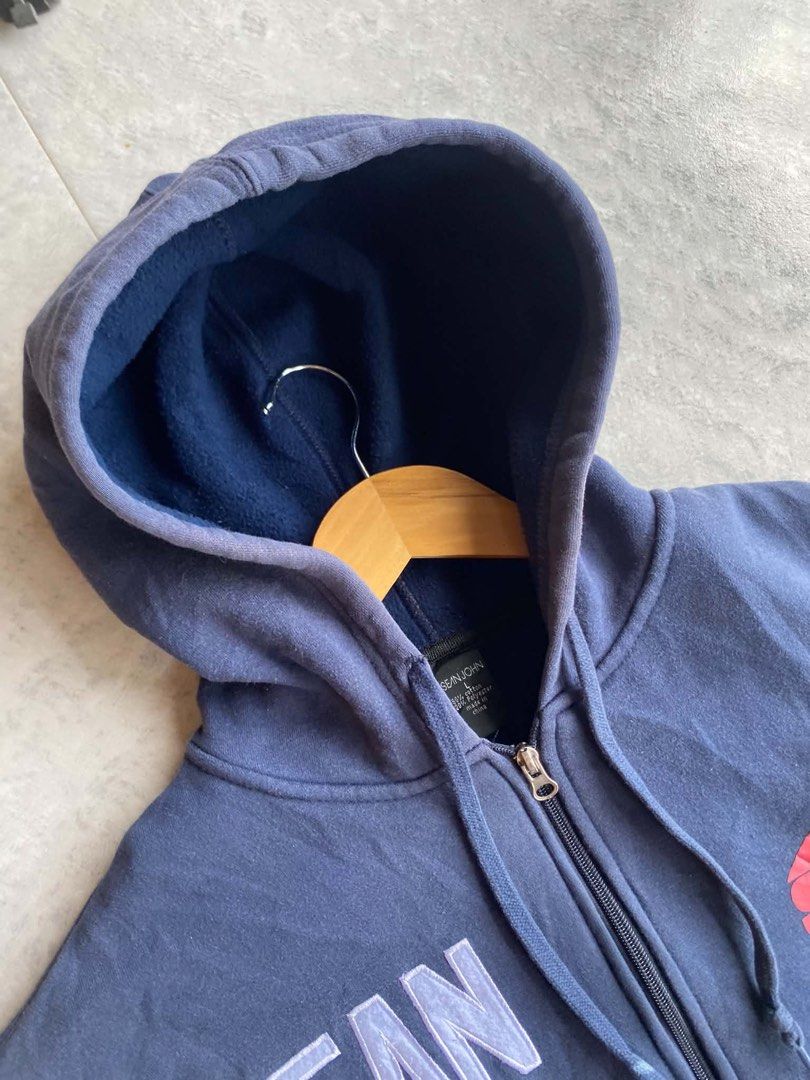 Sean John Navy Blue Zip-Up Hoodie (Category: Hoodies) located in Davao. Submitted by erwin_james (Listing ID 1452055199, Image 2). Description: -Vintage Sean John Hoodie Length - 29 Width - 26 Size on tag: Large Flaws: Uneven fade Color rate: 9/10 - Features "SEAN JOHN" and "69" graphics on the front - Front pocket and hood for comfort and style - Ribbed cuffs and hem for a snug fit.