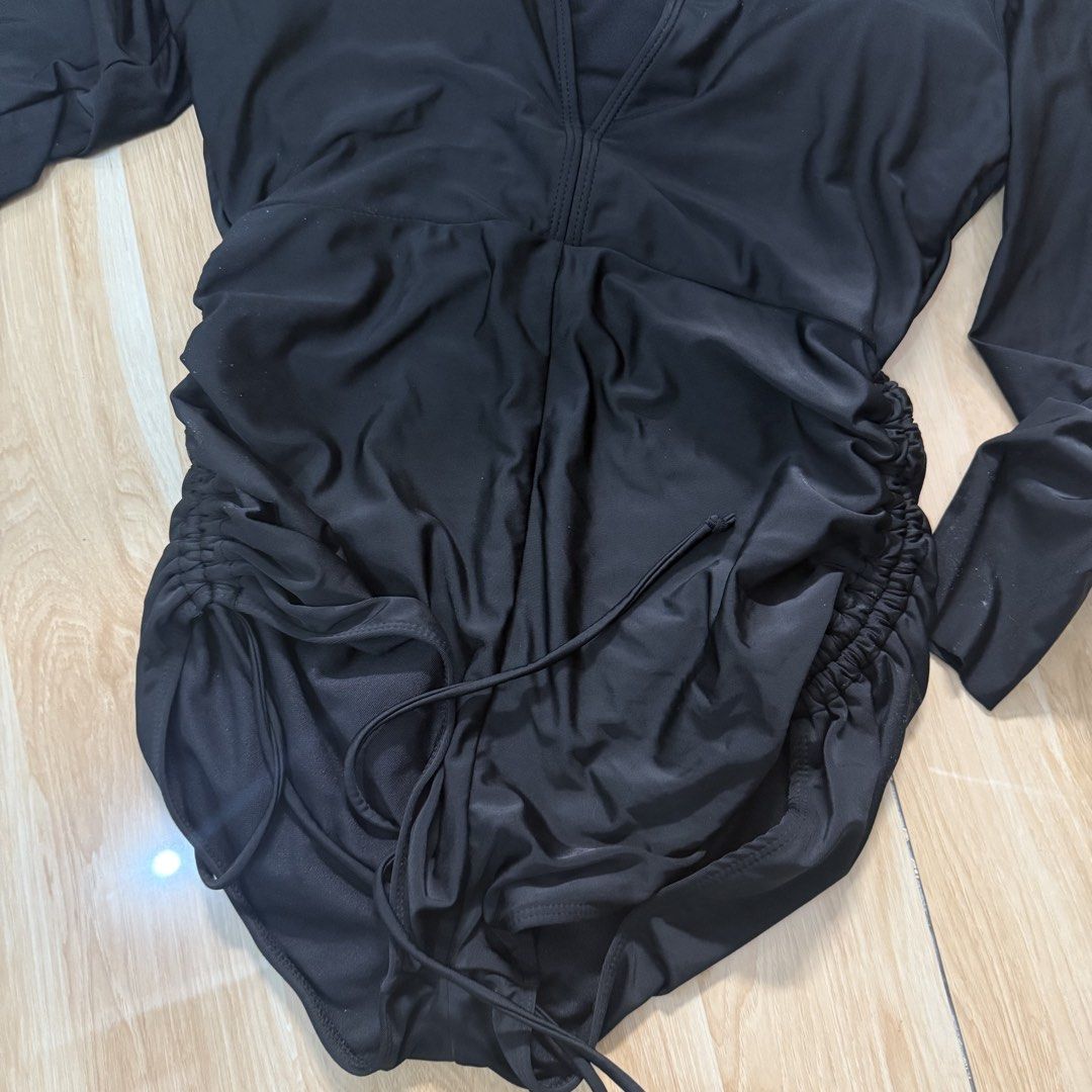 SHEIN Black Long Sleeve Ruched Swimsuit (Category: Bikinis & Swimsuits) located in Quezon City. Submitted by _seyer (Listing ID 1451973095, Image 3). Description: - Black long-sleeved one-piece swimsuit - Plunging neckline - Ruched sides with adjustable drawstring ties - Built-in bust padding - Ideal for swimming and beach days - Comfortable and stylish.