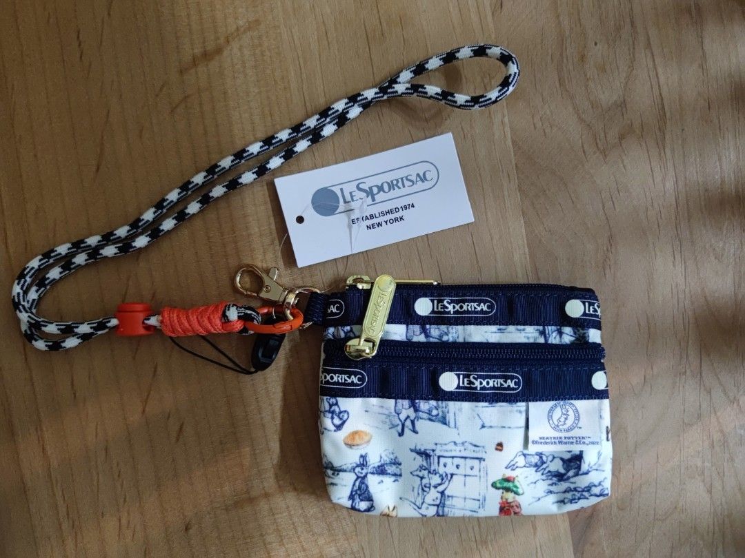 Small wallet （分類：手袋及銀包）位於 Hong Kong。 由 hh_maytulip 提交（商品編號 1452053932，圖片 1）。簡介： Hey there! Selling this super cute LeSportsac small wallet, perfect for keeping your essentials organized. It features a charming Beatrix Potter print with adorable bunnies and characters, set against a classic navy blue and white design. Comes with a handy lanyard so you can keep it close. Ideal for everyday use or as a lovely gift. Grab it before it's gone!。