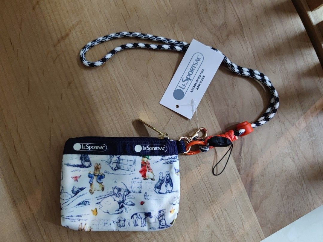 Small wallet （分類：手袋及銀包）位於 Hong Kong。 由 hh_maytulip 提交（商品編號 1452053932，圖片 2）。簡介： Hey there! Selling this super cute LeSportsac small wallet, perfect for keeping your essentials organized. It features a charming Beatrix Potter print with adorable bunnies and characters, set against a classic navy blue and white design. Comes with a handy lanyard so you can keep it close. Ideal for everyday use or as a lovely gift. Grab it before it's gone!。