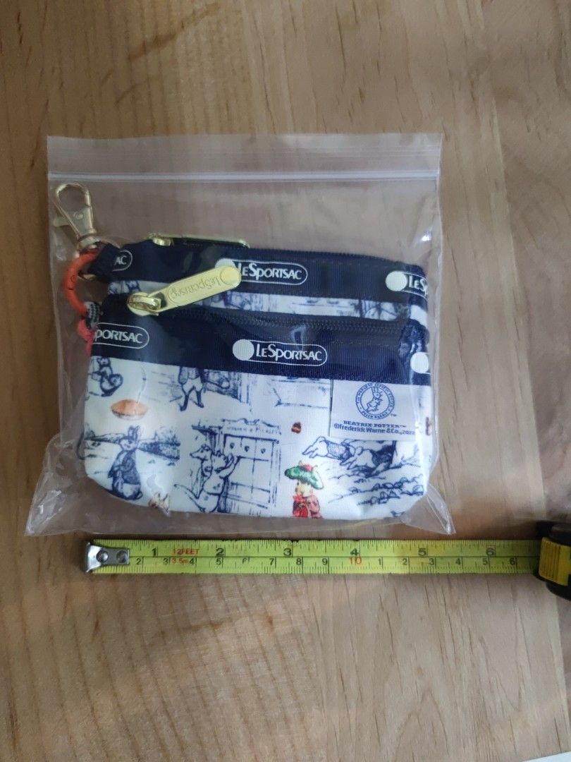 Small wallet （分類：手袋及銀包）位於 Hong Kong。 由 hh_maytulip 提交（商品編號 1452053932，圖片 3）。簡介： Hey there! Selling this super cute LeSportsac small wallet, perfect for keeping your essentials organized. It features a charming Beatrix Potter print with adorable bunnies and characters, set against a classic navy blue and white design. Comes with a handy lanyard so you can keep it close. Ideal for everyday use or as a lovely gift. Grab it before it's gone!。