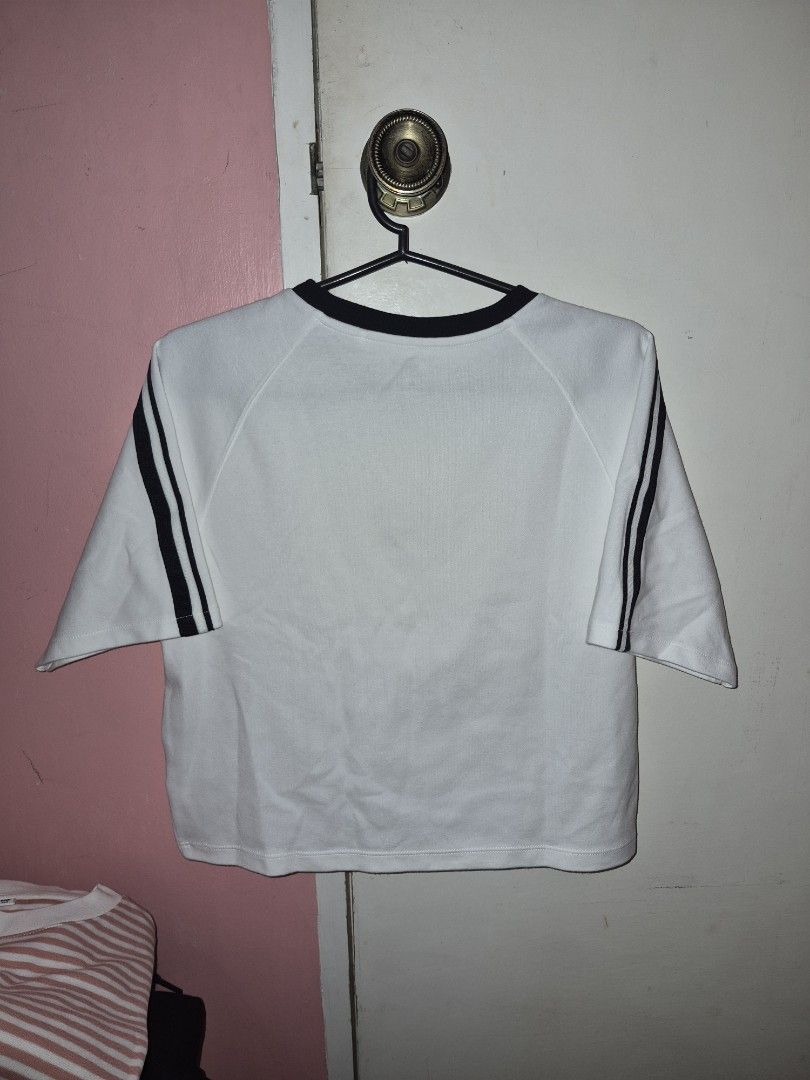 UNIQLO cropped T-shirt (Category: Shirts) located in Bulacan. Submitted by mrk_mdl (Listing ID 1452044526, Image 3). Description: - Brand: UNIQLO - Color: White with black stripes on sleeves and collar - Size: 150 cm kids (fits small) - Origin: Made in Cambodia - Style: Simple, classic, great for everyday wear.