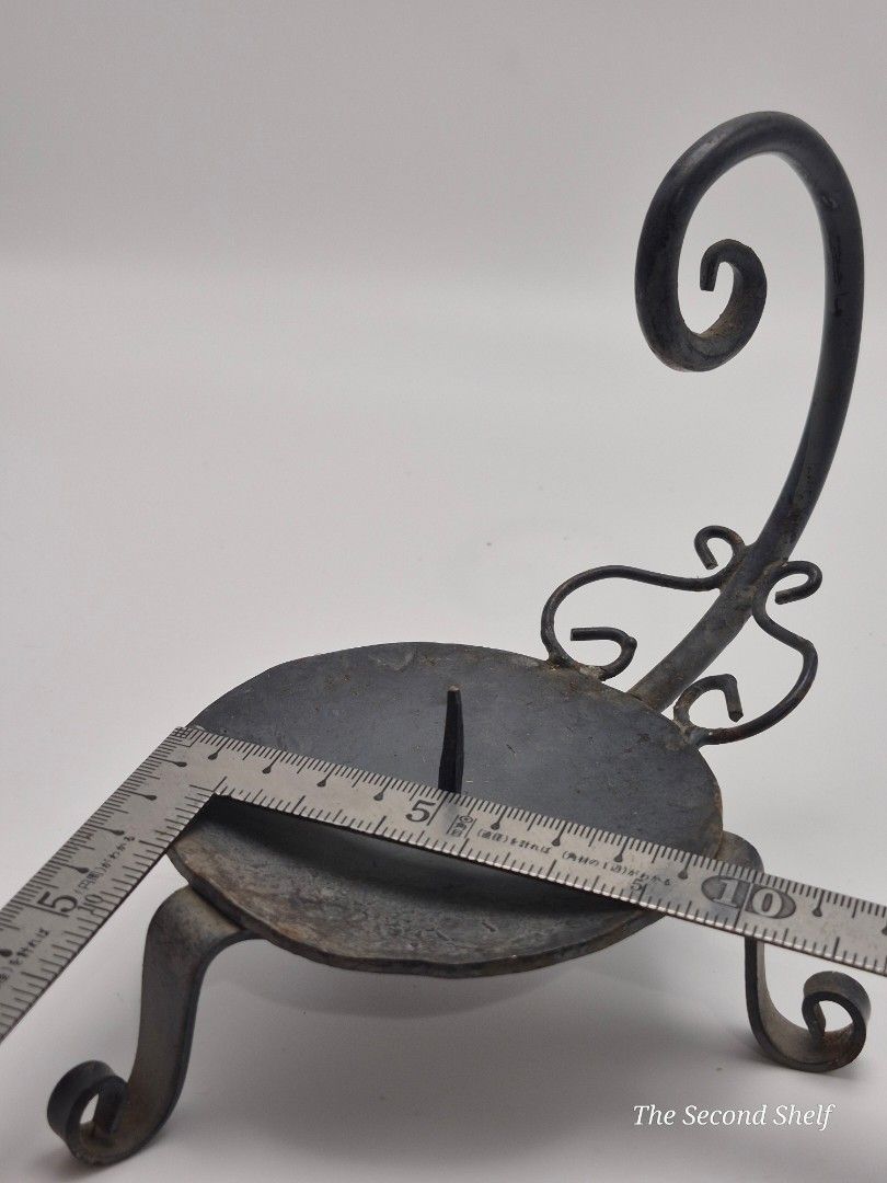 Vintage Hand-Forged Iron Chamber Candlestick (Category: Other Home Decor) located in Santa Rosa. Submitted by thesecondshelf (Listing ID 1451938105, Image 3). Description: Vintage Hand-Forged Iron Chamber Candlestick A handcrafted wrought iron chamber candlestick with a curled handle and tripod feet. Its simple blacksmith-made design makes it a charming decorative piece for rustic, farmhouse, medieval, or primitive-inspired interiors. • Hand-forg