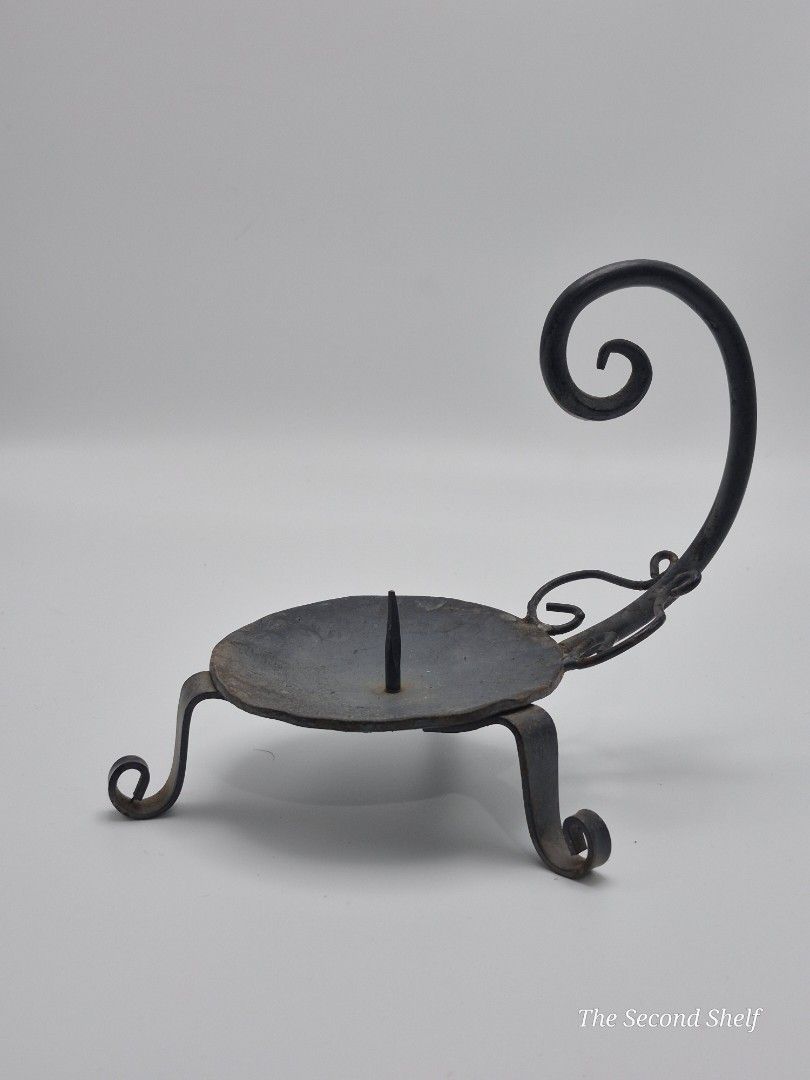 Vintage Hand-Forged Iron Chamber Candlestick (Category: Other Home Decor) located in Santa Rosa. Submitted by thesecondshelf (Listing ID 1451938105, Image 1). Description: Vintage Hand-Forged Iron Chamber Candlestick A handcrafted wrought iron chamber candlestick with a curled handle and tripod feet. Its simple blacksmith-made design makes it a charming decorative piece for rustic, farmhouse, medieval, or primitive-inspired interiors. • Hand-forg