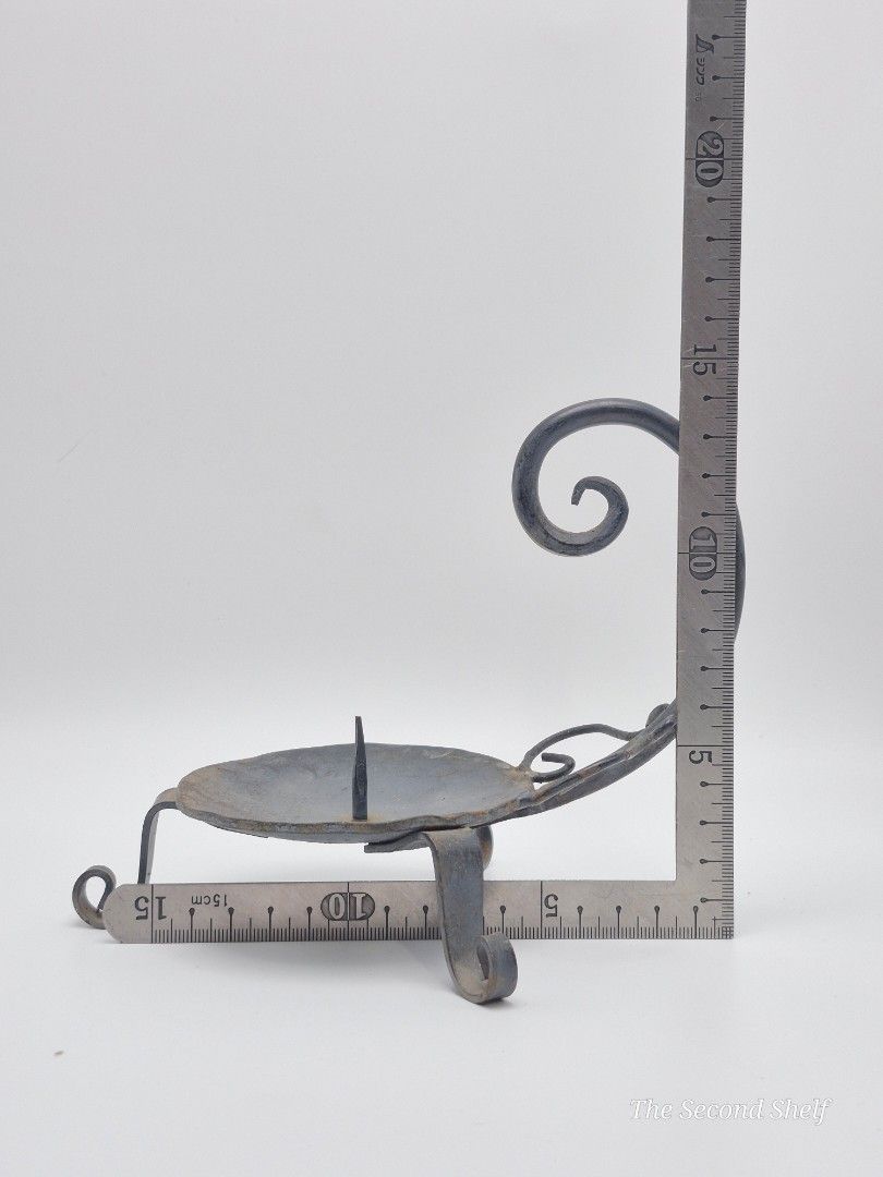 Vintage Hand-Forged Iron Chamber Candlestick (Category: Other Home Decor) located in Santa Rosa. Submitted by thesecondshelf (Listing ID 1451938105, Image 2). Description: Vintage Hand-Forged Iron Chamber Candlestick A handcrafted wrought iron chamber candlestick with a curled handle and tripod feet. Its simple blacksmith-made design makes it a charming decorative piece for rustic, farmhouse, medieval, or primitive-inspired interiors. • Hand-forg