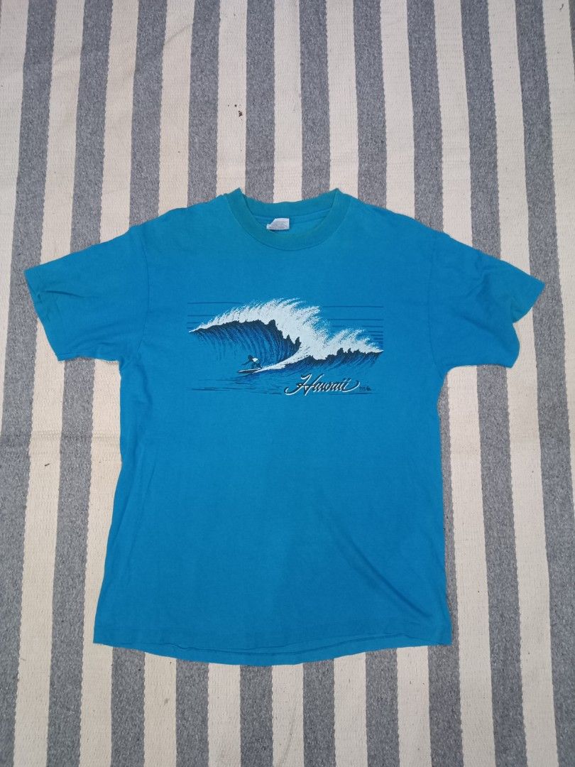 Vintage Hanes Hawaii Surf T-Shirt (Category: Tshirts & Polo Shirts) located in Kuala Lumpur. Submitted by truemountain-348cda (Listing ID 1452041790, Image 1). Description: - Cool blue t-shirt pit 12.5/lbuh 29 - Size: Large - Brand: Hanes - Classic Hawaii surf graphic with surfer riding a big wave - Graphic includes 'Hawaii' in script - Copyright date 1985 visible on graphic.