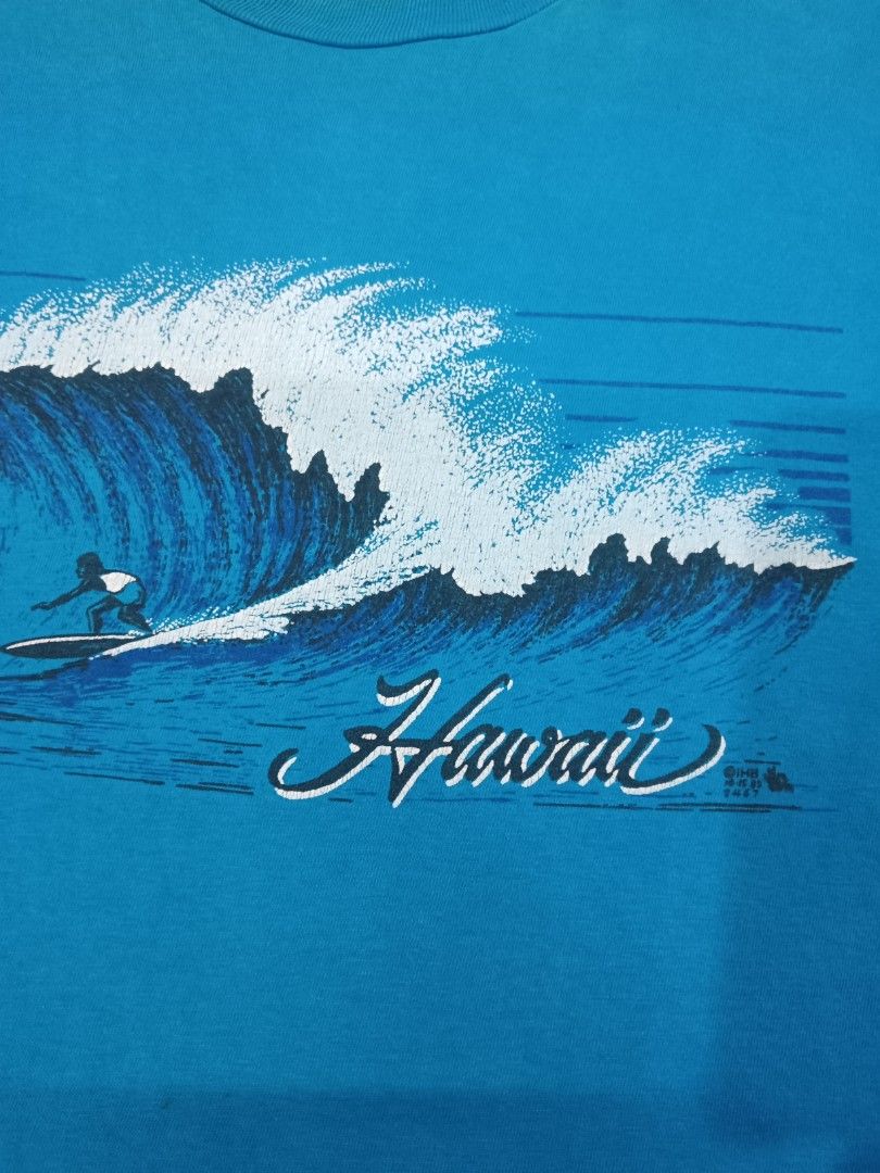 Vintage Hanes Hawaii Surf T-Shirt (Category: Tshirts & Polo Shirts) located in Kuala Lumpur. Submitted by truemountain-348cda (Listing ID 1452041790, Image 2). Description: - Cool blue t-shirt pit 12.5/lbuh 29 - Size: Large - Brand: Hanes - Classic Hawaii surf graphic with surfer riding a big wave - Graphic includes 'Hawaii' in script - Copyright date 1985 visible on graphic.