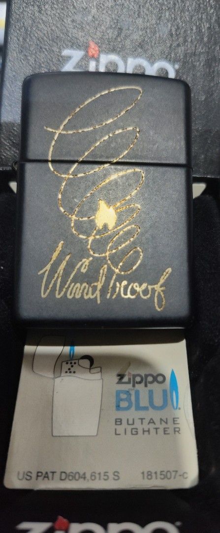SWAP/SALE Zippo Windproof Butane Lighter - AUTHENTIC (Category: Hiking & Camping) located in Manila. Submitted by karuselkoh (Listing ID 1451927199, Image 2). Description: - Zippo butane lighter - Classic black finish with gold 'Windproof' design - Back features text about Zippo flame history - Made in USA - Includes original box AUTHENTIC 100% OFFER LANG KUNG SWAP.