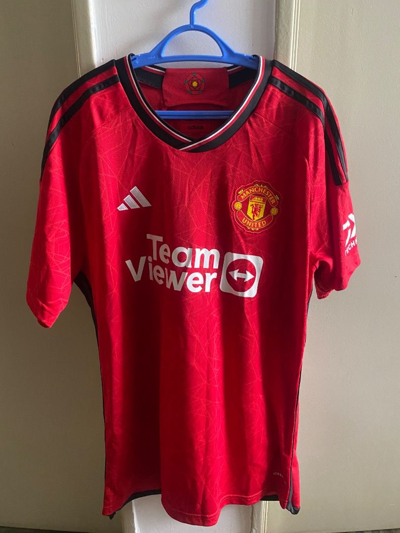 Adidas Manchester United 2022/23 Home Jersey (Category: Activewear) located in Kuala Lumpur. Submitted by awadah.cloud (Listing ID 1452127417, Image 1). Description: - Authentic Adidas Manchester United 2022/23 Home Jersey - Features the iconic TeamViewer sponsor - Classic red design with stylish black accents - A must-have for any Manchester United supporter.