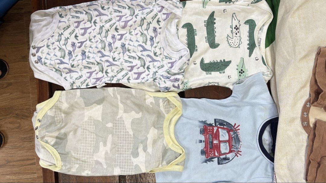 Baby Bodysuits and Shorts Bundle - Various Prints (Category: Babies & Kids Fashion) located in Mangaldan. Submitted by prelovedstuffcm (Listing ID 1452106159, Image 1). Description: - Bundle includes 8 pieces of baby clothing. - Features 4 short-sleeve bodysuits with fun prints: dinosaurs, alligators, camouflage, and a red truck. - Comes with 4 pairs of shorts in versatile colors and prints: brown, mustard yellow, and two with a tree print. - Ide