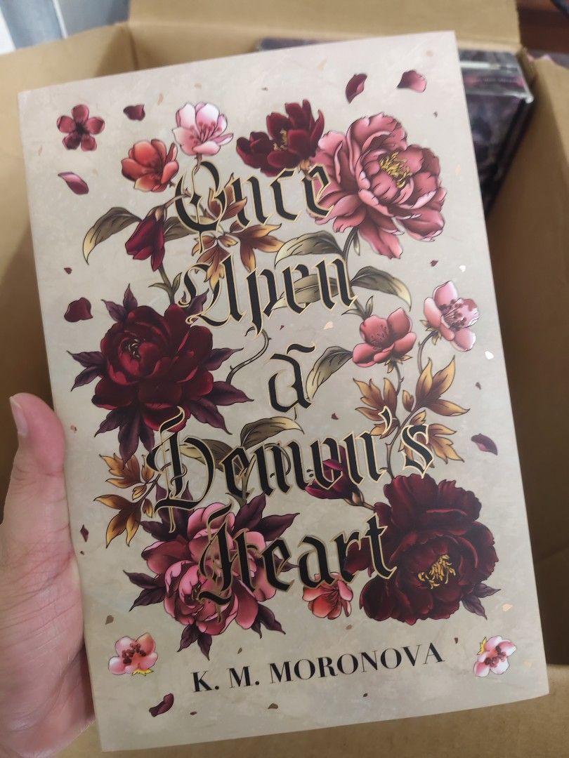 BB Once Upon a Demon's Heart by K.M. Moronova (Category: Storybooks) located in Baguio. Submitted by selover1492 (Listing ID 1452297639, Image 1). Description: Hardcover book 'Once Upon a Demon's Heart' by K.M. Moronova. Features a beautiful floral cover with gold foil and floral endpapers. Perfect for fantasy fans!.