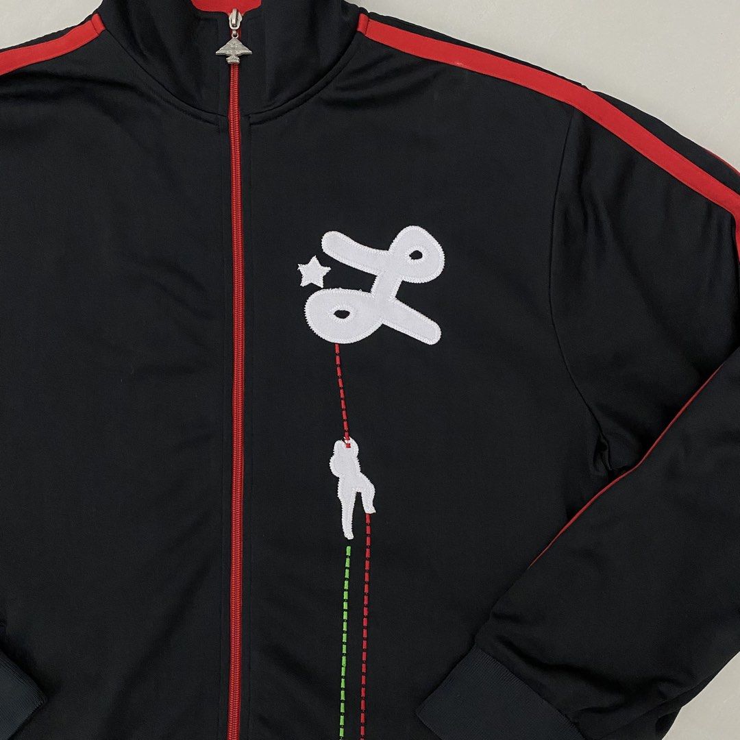 Y2k LRG track jacket (Category: Activewear) located in Cavite. Submitted by mana__ (Listing ID 1452261747, Image 2). Description: - Black track jacket - Red stripe details on sleeves and collar - Unique front graphic (star, stylized 'L', climber) - Zipper pull with tree-like emblem - Ideal for casual wear - XXL Width - 25 Length - 29.5 Shoulders - 19.5 Sleeve - 24.5 Hem - 22 Very good * loose stitch.