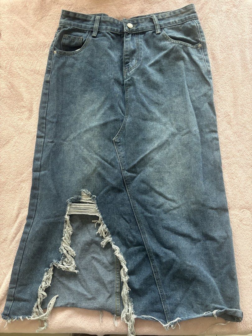 Blue Denim Midi Skirt with Rips (Category: Skirts) located in Tarlac. Submitted by wekewl (Listing ID 1452176496, Image 1). Description: - Blue denim midi skirt - Distressed, ripped design on front - Raw hemline - Classic five-pocket styling - Button and zip closure - Ideal for a casual, edgy outfit - Pairs well with tops and sneakers.