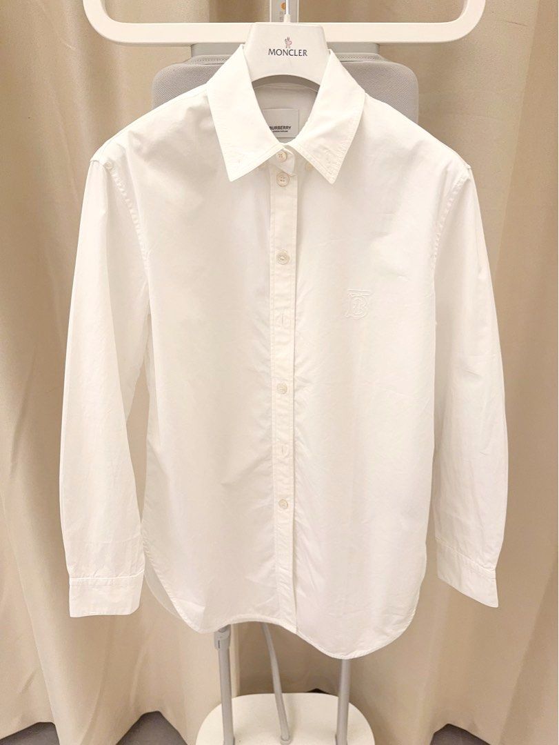 由 bobe56899 (刊登 ID 1452312395，圖片 1) 提交，位於 新北市 (New Taipei) 的 英國🇬🇧 BURBERRY 品牌❤️專櫃購買 保證100%正品🌟女士TB刺繡白色襯衫❤️實品超級美！原價一萬多超低價割愛❤️買到賺到😊 (類別：精品服飾)，說明：BURBERRY品牌❤️ 加拿大專櫃購買保證100%正品⭐️ 女士白色經典款襯衫🌟 胸前有Burberry TB刺繡設計 低調又好看很時尚🌟這件剪裁特別好 白襯衫單穿or當外罩內裡配背心穿都好看❤️ 原價一萬多 超低價割愛❤️ 肩寬：40 cm 胸圍平量：48 cm 全長：72 cm Size :UK2 有任何問題歡迎留言 謝謝😊🤝。