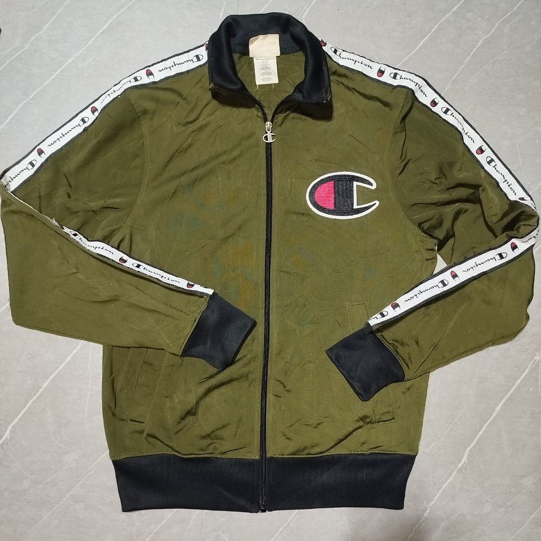 Champion Track Jacket Olive Green with Logo Tape (Category: Coats, Jackets and Outerwear) located in Davao. Submitted by vernoneighty4 (Listing ID 1452263549, Image 2). Description: - Olive green Champion track jacket - Classic Champion C logo on chest - White tape with Champion branding down sleeves - Ribbed cuffs and hem for a snug fit - Full zip closure for easy wear - Ideal for casual outings or athletic activities - small W22 L27.