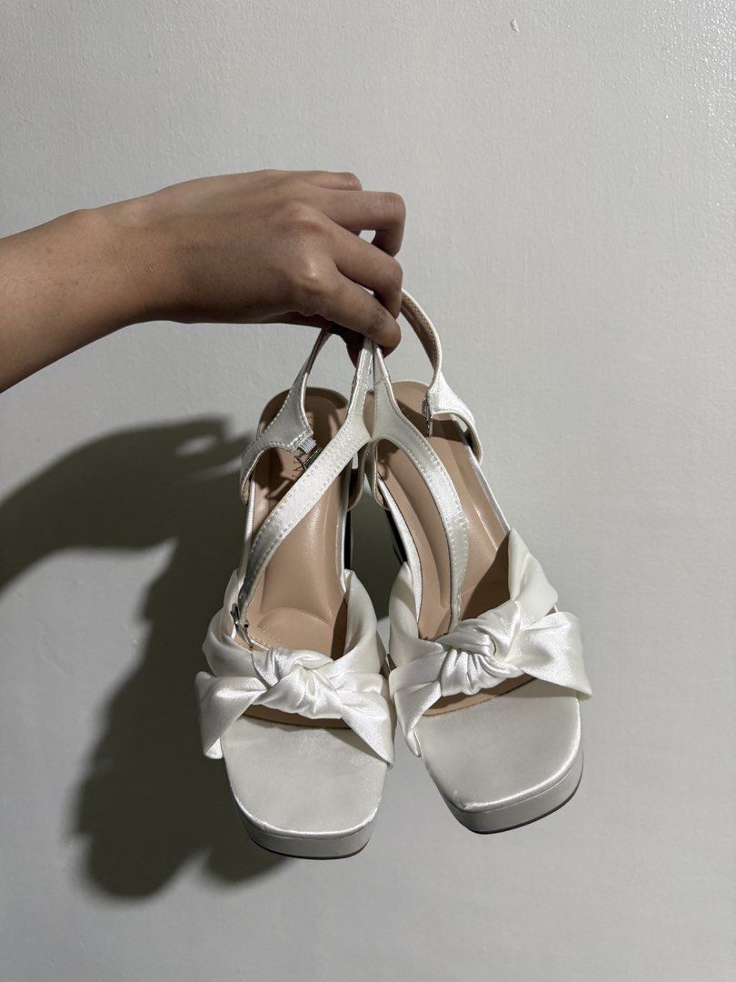 Chiyako Mikana White Bow Platform Block Heels (Category: Heels) located in Mandaluyong City. Submitted by mkaba (Listing ID 1452260328, Image 1). Description: - White platform block heels - Cute bow detail on the front - Strappy design with adjustable ankle strap - Heel height: approximately 4.5 inches - Ideal for dressing up or special occasions - Comfortable platform sole for all-day wear.