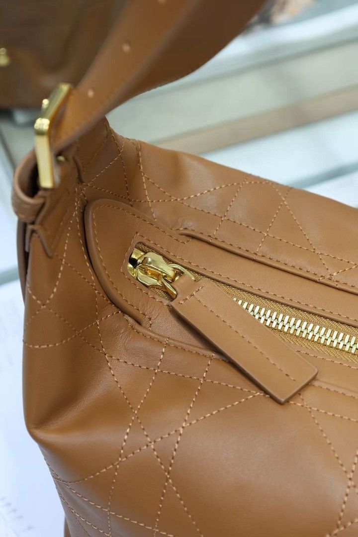 DIOR Quilted Leather Hobo Bag (Category: Luxury Bags & Wallets) located in Manila. Submitted by aise08 (Listing ID 1452242632, Image 1). Description: Brown leather Dior hobo bag. Quilted stitching all over. Gold hardware details, including zippers. Interior has a zip pocket and a tag that says Christian Dior. Spacious main compartment. Adjustable strap..