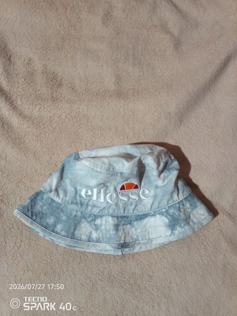 Ellesse Tie-Dye Bucket Hat (Category: Hats & Beanies) located in Bislig. Submitted by micoy22 (Listing ID 1452211684, Image 1). Description: - Brand: Ellesse - Style: Tie-dye bucket hat - Color: White and blue pattern - Features: White embroidered Ellesse logo on front - Size: One size fits most - Ideal for: Sunny days.