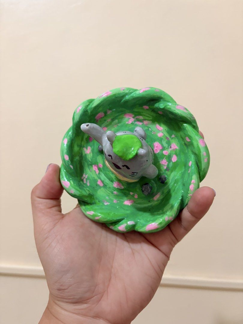 Handmade Totoro Trinket Dish with Cherry Blossoms (Category: Dinnerware & Cutlery) located in Manila. Submitted by dapdappung (Listing ID 1452180382, Image 2). Description: - Cute handmade trinket dish - Features Totoro on a leafy base - Decorated with pink cherry blossoms - Perfect for holding small jewelry or keys - Unique gift for Studio Ghibli fans - Adds a touch of magic to desks or dressers.
