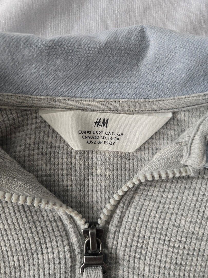 H&M Grey Adventure Zip-Up Sweater (2T) (Category: Babies & Kids Fashion) located in Manila. Submitted by shla.dln (Listing ID 1452167844, Image 2). Description: - Grey waffle knit sweater from H&M - Blue collar and zipper at the neck - 'ADVENTURE' text with llama graphics on the front - Ideal for everyday wear - Easy to put on and take off.