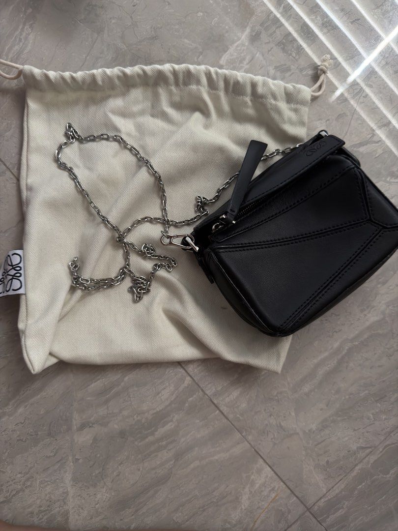 Loewe Black Leather Puzzle Mini Bag with Dust Bag (Category: Luxury Bags & Wallets) located in Antipolo. Submitted by 2ammom (Listing ID 1452136521, Image 1). Description: - Black Leather Loewe Puzzle Bag - Mini Size - Includes Dust Bag - Palladium Chain Strap - Zipper Closure - Embossed Loewe Logo on Flap and Zipper Pull - Ideal for carrying wallets, cards and small items.