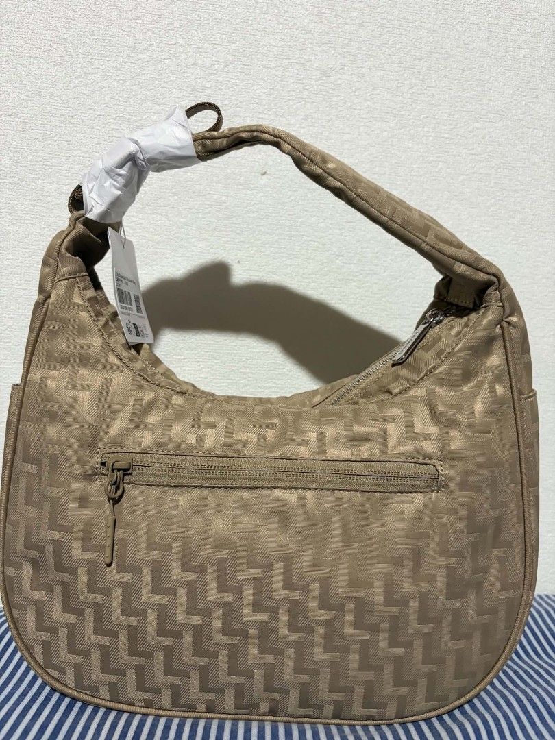 Lululemon City Essentials Shoulder Bag - Tan Monogram (Category: Shoulder Bags) located in Taguig. Submitted by giango1313 (Listing ID 1452134063, Image 2). Description: - Authentic Lululemon shoulder bag - All-over repeating L monogram pattern - Secure top zipper closure - Convenient exterior zip pocket on the back - Adjustable strap for comfortable wear - Comes with original tags attached.