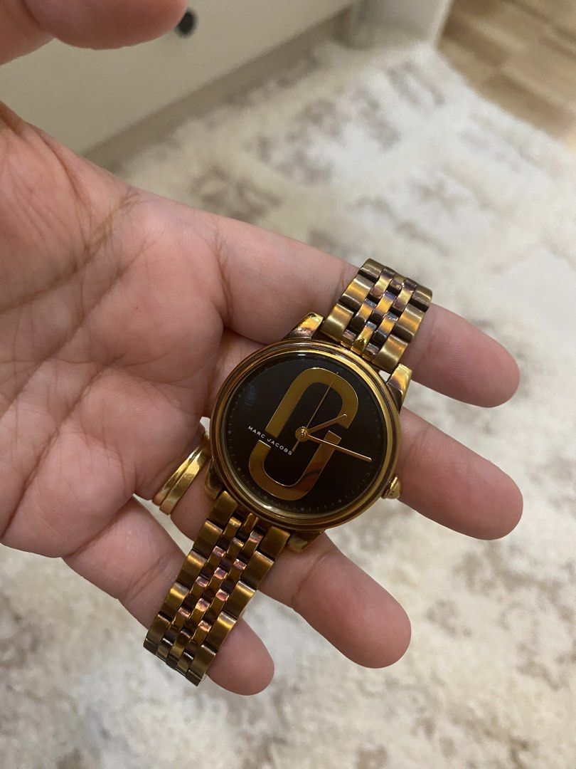 Marc Jacobs Gold Tone Watch (Category: Women's Watches) located in Bulacan. Submitted by aksantos10 (Listing ID 1452214011, Image 2). Description: - Gold tone Marc Jacobs watch - Features iconic MJ logo on the face - Gold tone band - Classic and versatile design - Perfect for everyday wear or dressing up.