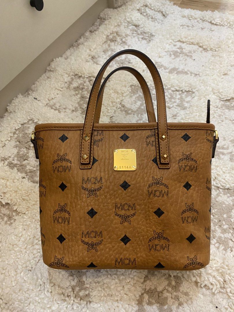MCM Visetos Mini Tote Bag (Category: Luxury Bags & Wallets) located in Bulacan. Submitted by aksantos10 (Listing ID 1452212605, Image 1). Description: - Classic MCM tote bag - Signature Visetos print (tan brown with black MCM logo) - Gold-tone hardware and MCM logo plate - Top handles .