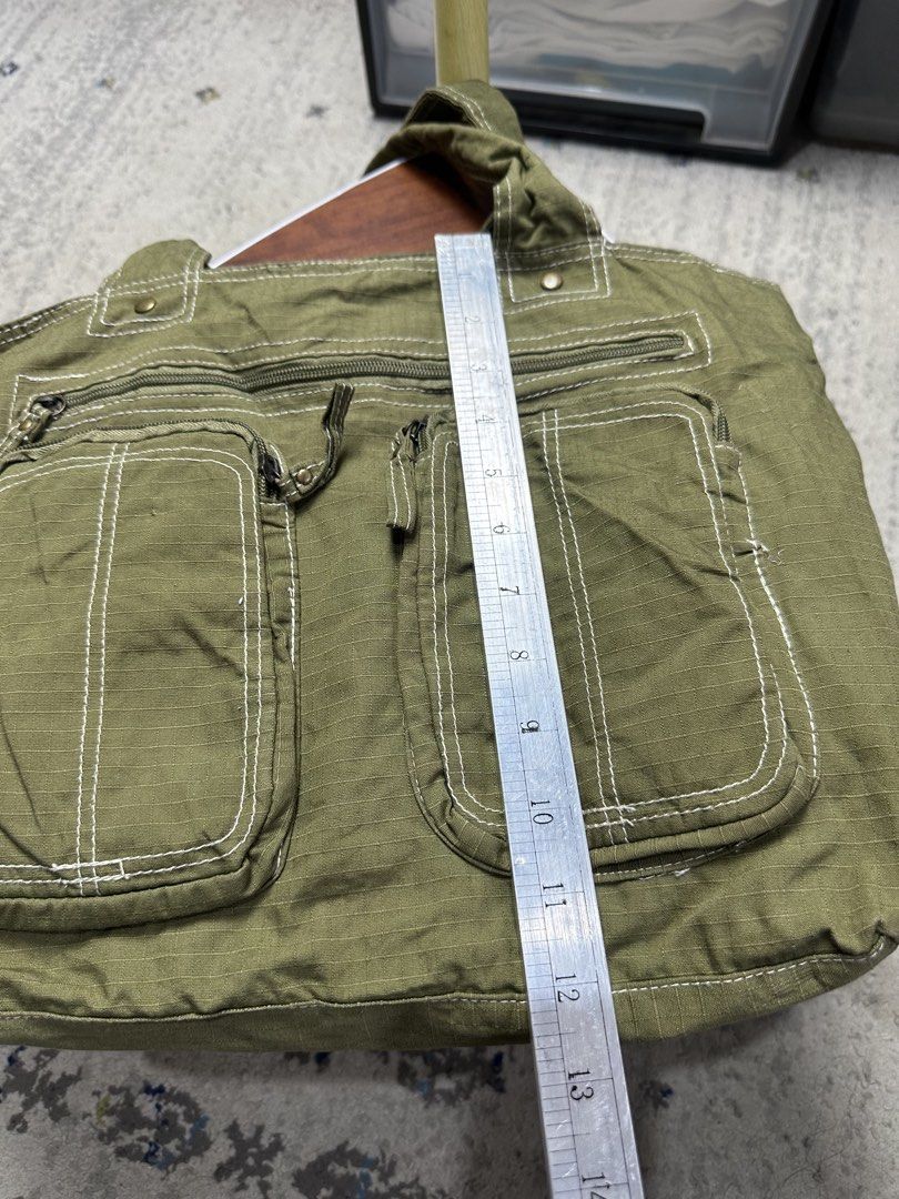 Mossimo Supply Co. Olive Green Canvas Cargo Tote Bag (Category: Tote Bags) located in Daet. Submitted by thrifthings2018 (Listing ID 1452212799, Image 2). Description: - Olive green canvas tote bag from Mossimo Supply Co. - Multiple easy-access pockets on the front - Secure zipper closure on top - Spacious interior for all your essentials - Ideal for everyday use.