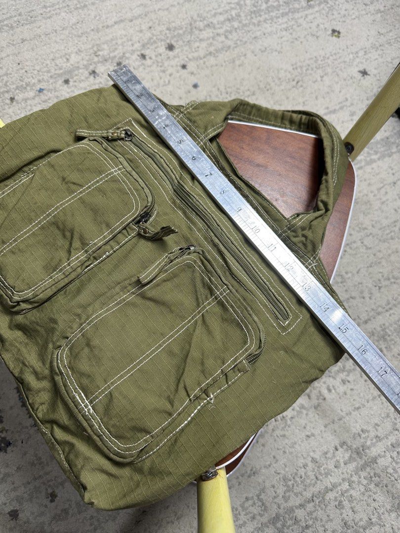 Mossimo Supply Co. Olive Green Canvas Cargo Tote Bag (Category: Tote Bags) located in Daet. Submitted by thrifthings2018 (Listing ID 1452212799, Image 3). Description: - Olive green canvas tote bag from Mossimo Supply Co. - Multiple easy-access pockets on the front - Secure zipper closure on top - Spacious interior for all your essentials - Ideal for everyday use.