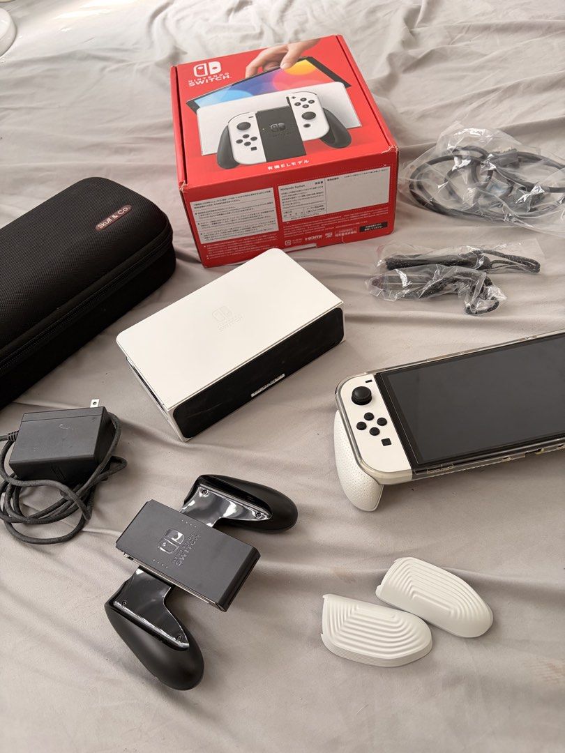 Nintendo Switch OLED White Console with Accessories (Category: Nintendo) located in Malabon City. Submitted by Maktub_01 (Listing ID 1452120187, Image 2). Description: Guaranteed Good as New! - Nintendo Switch OLED Model (White) - Includes original dock and Joy-Cons - Comes with Joy-Con straps and grip accessory - Original box included - Bonus travel hard case for gaming on the go - All necessary cables are provided - Ready for both home console 