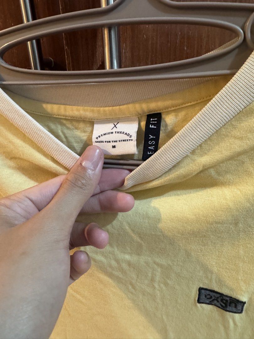Oxgn Premium Threads Easy Fit T-shirt Size M (Category: Tshirts & Polo Shirts ) located in Manila. Submitted by ianventory (Listing ID 1452255574, Image 2). Description: - Yellow Oxgn t-shirt - Size: Medium (M) - White trim on collar and sleeves - Small Oxgn logo on chest - Additional Oxgn tag near hem - Easy fit, comfortable for casual wear.