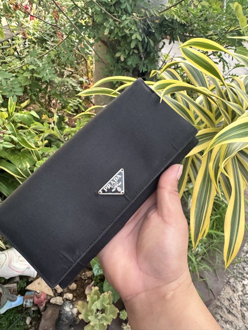 Prada Black Nylon Wallet (Category: Luxury Bags & Wallets) located in Cainta. Submitted by danica010314 (Listing ID 1452277361, Image 1). Description: - Classic black Prada wallet - Made in Italy - Durable nylon exterior with luxurious leather interior - Ample card slots for organization - Zippered compartment for coins or small items - Secure snap closure - Ideal for everyday use.