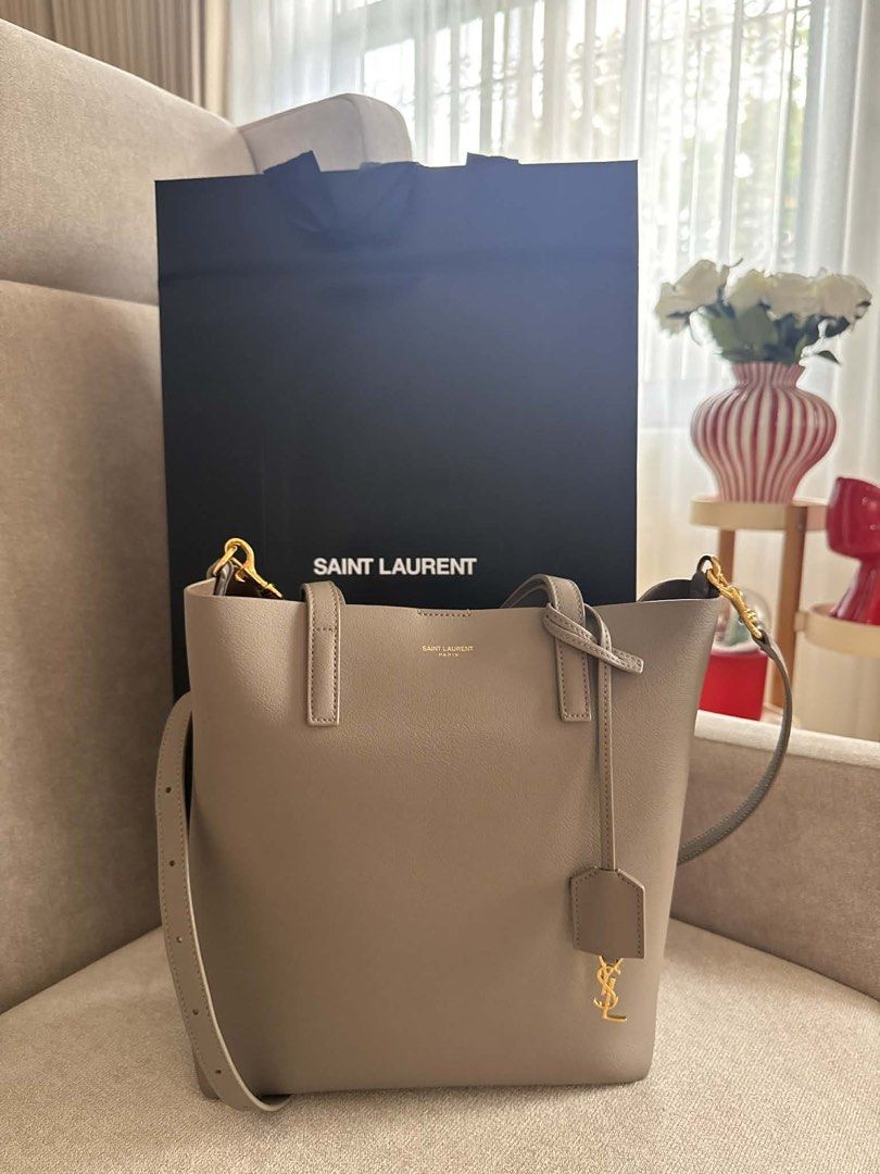 Saint Laurent Grey Leather Tote Bag (Category: Luxury Bags & Wallets) located in Batangas. Submitted by jereeemie (Listing ID 1452145586, Image 1). Description: - Genuine Saint Laurent grey leather tote bag - Features iconic YSL logo charm - Comes with a detachable strap for versatile carrying - Includes original Saint Laurent dust bag - Ideal for everyday use.