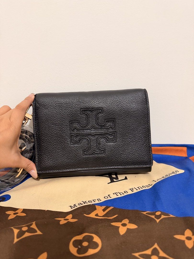 Tory Burch Black Leather Wallet with Strap (Category: Luxury Bags & Wallets) located in Angeles City. Submitted by kimkim_06_614 (Listing ID 1452261947, Image 2). Description: - Brand: Tory Burch - Material: Black pebbled leather - Design: Embossed signature T logo - Features: Detachable leather strap with gold hardware - Interior: Zip pocket and multiple card slots - Condition: Clean inside and out - Perfect for carrying your essentials.